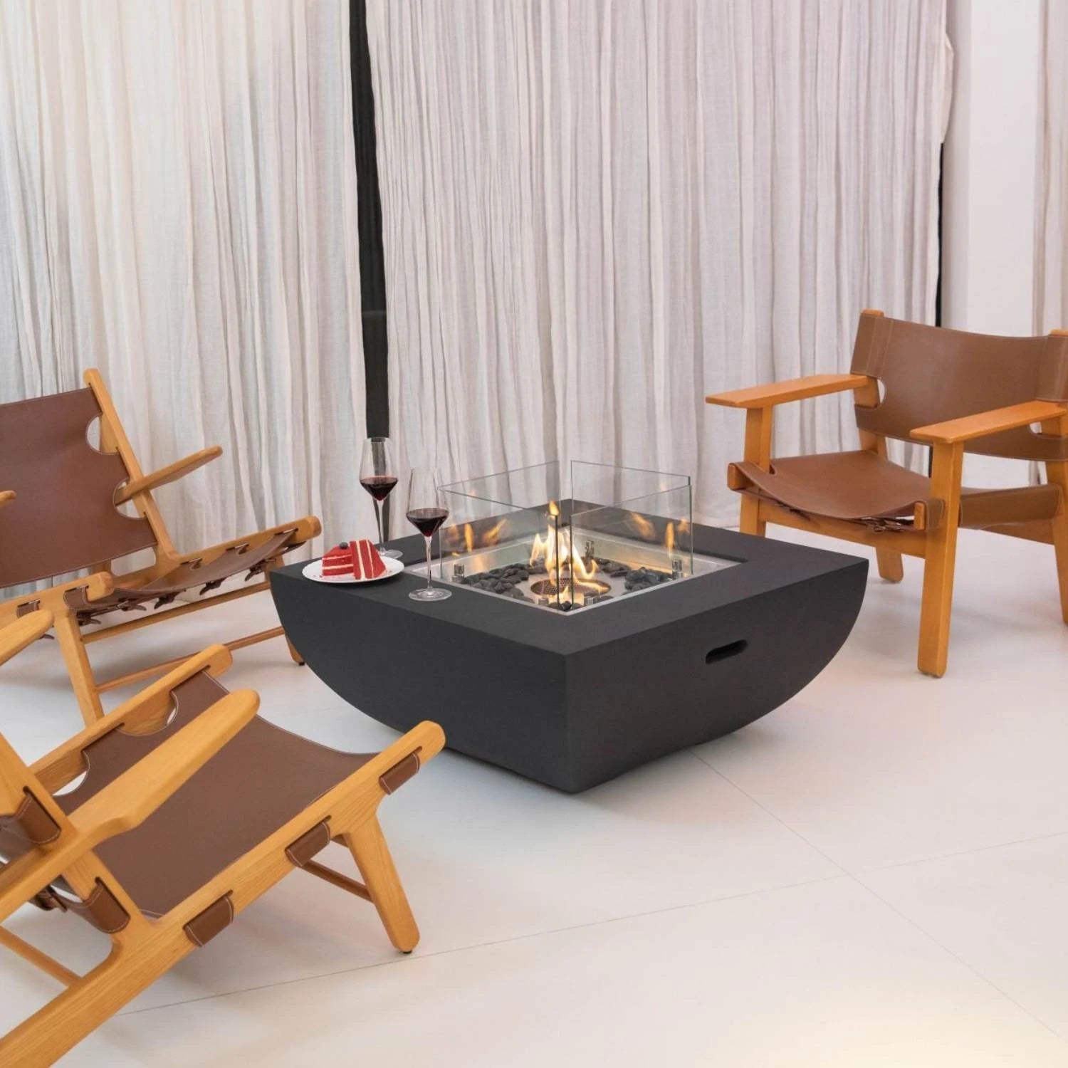 Aurora bioethanol fire pit in matte black with glass windscreen and bronze fire glass