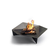 Höfats TRIPLE 120 Fire Pit in Corten Steel with burning logs, placed on a white surface.